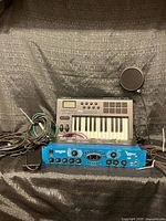 Lot overview showing Behringer rack unit, M-Audio keyboard, cables and pop filter