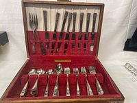 Open wood case showing full flatware set