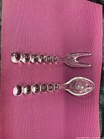 Full view of fork and spoon displaying orb handles and size comparison