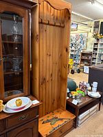 Full front view of knotty pine rod rack beside other furniture