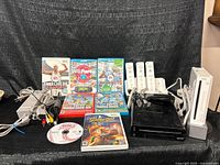 Overall lot showing both consoles, controllers, games and cables