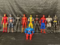 Group shot of all ten 12-inch figures standing in a row with one crouching in front