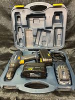 Case open showing drill, two batteries, charger positioned in molded slots