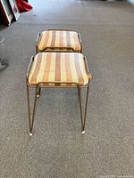 Front view of both striped leatherette stools on carpet