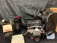 Full lot view showing camera, lenses, flash, bag, receipt