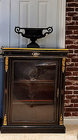 Front view of ebonized pier cabinet with urn on top (urn not included)