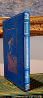 Front and spine view of the blue leather bound book with gold embossed marlin design and gold spine text.