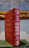Front angled view of the red leather spine and part of front cover with gold ornate decorations and text showing author, title and Franklin Library brand.