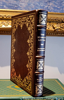 Front and spine view of the leather bound book with gold embossed title 'The Scarlet Letter Nathaniel Hawthorne' and decorative gold leaf floral designs on spine and cover.
