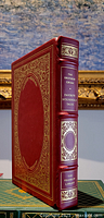 Full side view of the leather bound book showing intricate 22 karat gold decorations on the cover and spine with raised spine hubs.