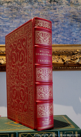 Full view of spine and partial cover showing gilt decoration, text, and raised spine hubs