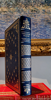Spine view of the leather bound book 'Treasure Island' showing gold decorations, title, author, and publisher name The Franklin Library.