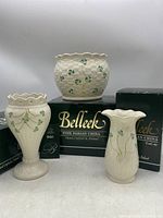 Three Belleek vases displayed on their original boxes, showing the overall shape, decoration and condition.