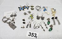 Photo showing wide view of all various earrings including sterling marked pieces with tags and a variety of animal and nature designs.