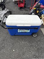 Front and top view of blue and white Igloo Glide Roller cooler with handle and wheels.