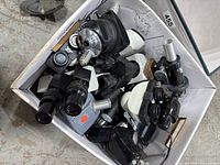 Top view of assorted microscope lenses and scopes in a box
