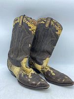 Pair of Montana cowboy boots made in Mexico, brown leather with snake skin accents visible on the shaft, heel, and toe box, photographed from side.