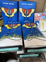 Four unopened butterfly-themed handmade Chinese kites in original blue and white boxes labeled Tianjin Rites