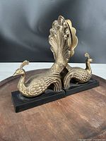 Side angle view showing brass peacock figure and base.