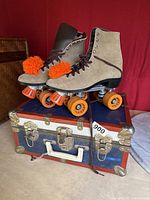 Side angle view of vintage women's roller skates and hard travel case beneath