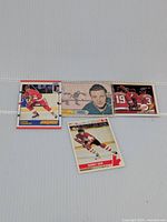 Four different hockey cards laid out on a flat surface showing front sides of each card featuring various hockey players.