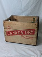 Front view of wooden crate with Canada Dry insignia and caption 'The Champagne of Ginger Ales'