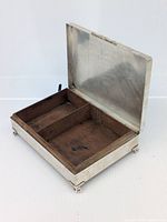 Open view showing interior wooden divided compartments and metal lid interior