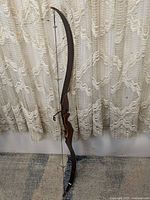 Full view of the Darton Thunderbird reflex bow showing overall shape, dark finish, string attached, and size.