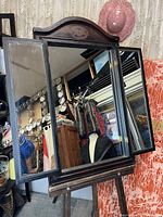 Front view of the mirror with the two side doors open showing the mirrored panels and central mirror.