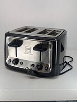 Front view showing toaster controls, plug, and 4 bread slots