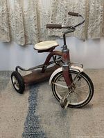 Side angle showing the Troxel tricycle's frame, seat, and rear wheels.