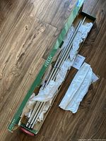 Photo of assembled silver metal tubes and wooden top of wind chime in packaging with wrapping paper.