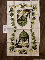 Full view of the linen tea towel featuring green globe and maple leaf border design commemorating Canada's 1967 centennial.