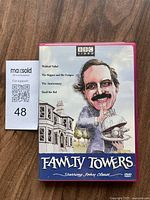 Front cover of Fawlty Towers Volume 3 DVD showing caricature of John Cleese and list of episodes