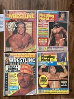 Four wrestling magazines showing cover images featuring Lex Luger, Hulk Hogan, Randy Savage, Andre the Giant, and others. Bright, colorful covers with wrestling action and promotional text.