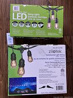 Photo of the green packaging label of the LED string lights showing the length 14.6m/48ft, 24 bulbs, duty 14 gauge wire, suitable for outdoor use.