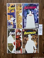 Overview photo of all six Batman comics in protective bags on wooden floor