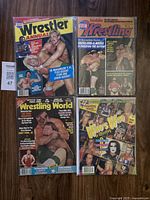 Four vintage wrestling magazines with colorful covers showing wrestlers and promotional imagery from mid-1980s and 1998.