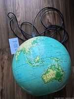 Photo showing the vintage globe pendant lamp resting showing the map details including Australia and Indonesia.