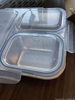 Close-up of transparent plastic snap lock lid with slight blue tint on edges.