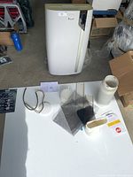 Overview showing AC unit and accessories on white board