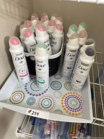 Overview of the 22 Dove Advanced Care dry body spray deodorant cans arranged mostly standing with different colored caps.