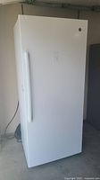 Front view of closed freezer showing white exterior and recessed handle