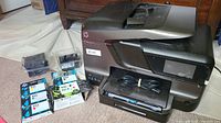 HP OfficeJet Pro 8600 Plus printer with ink cartridges and print heads arranged beside it