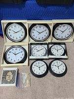 Overview of 10 wall clocks of various designs including boxed quartz clocks, Harold & Barnes, Eiffel Tower themed clocks and clock keys
