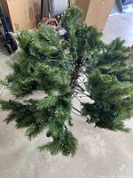 Photo of the un-assembled artificial tree segments showing green branches and central pole.