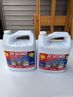 Front view of two identical 3.78L white plastic bottles of 30 Seconds Cleaner with red and blue labels on a white table.