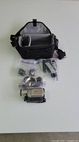 Full view of camcorder, accessories in plastic bags, and carrying case with open compartment.