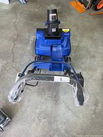 Front view of assembled snow blower with handle wrapped in plastic