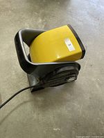 Full view side angle of the yellow and black Stanley heavy-duty blower fan with power cord.